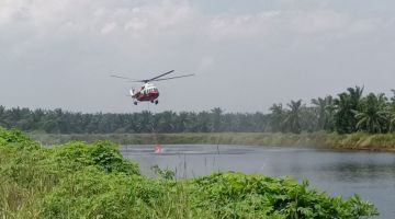 Helikopter Mi17 bomba menceduk air di kolam berdekatan lokasi kebakaran bagi memadamkan api. 