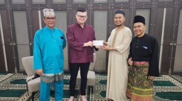 Dr Yii (dua kiri) menyerahkan sumbangan dana kepada pihak pengurusan Masjid Wan Alwi, Tabuan Jaya semasa majlis berbuka puasa, baru-baru ini.