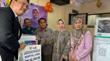 Rosey menyerahkan mesin hemodialisis kepada Pengarah Hospital Lundu Dr Chin Shi How. Turut kelihatan, bekas Pengerusi Lembaga Amanah Kebajikan Islam Lundu Datuk Amar Jamilah Anu (kanan).