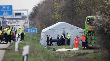 Pegawai perkhidmatan rumah mayat mengangkat mayat mangsa yang terbunuh dalam nahas bas di lebuh raya A9 di Schkeuditz, berdekatan Leipzig kelmarin. — Gambar AFP