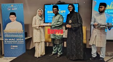 SUMBANGAN: Mustapha (dua kiri) menyampaikan sumbangan sempena Program Semarak Ramadan KPT kepada salah seorang penerima pada majlis itu.