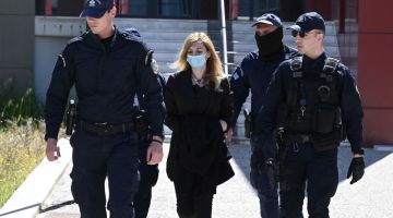 Pegawai polis mengiringi Pispirigou (tengah) di luar mahkamah di Athens kelmarin. — Gambar AFP