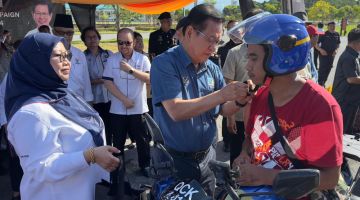 Lee meri topi pengelikun ngagai penguna mutosikal ke bisi ngetu ba PETROS Multifuel Station Darul Hana nyerumba pengawa bejadi kimpin nya kemari. -Gambar Kong Jun Liung