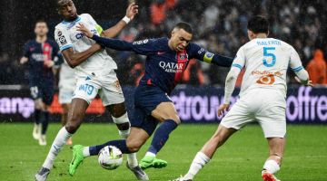 Aksi Mbappe (tengah) ketika diturunkan dalam kesebelasan utama pada perlawanan Ligue 1 Perancis di antara Marseille dan PSG pada 31 Mac lalu di Stade Velodrome di Marseille. — Gambar AFP