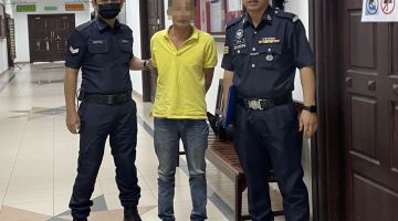 Tertuduh (tengah) diiring polis dan Mohammad Asfia (kanan) semasa berada di lobi Mahkamah Kuching, hari ini.
