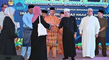 SERAH: Hajiji menyampaikan sumbangan kepada asnaf pada Majlis Berbuka Puasa bersama Ketua Menteri di perkarangan Masjid An-Nur Tuaran pada Jumaat.