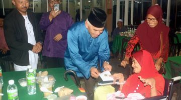 SERAH: Yusof ketika menyampaikan bantuan.