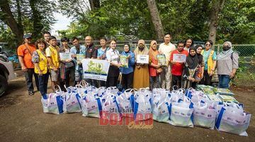 SUMBANGAN: Darren, Winnie dan wakil daripada Pertubuhan Kebajikan San Chuan Sabah serta Lion Club mengagihkan bakul makanan kepada mangsa kebakaran