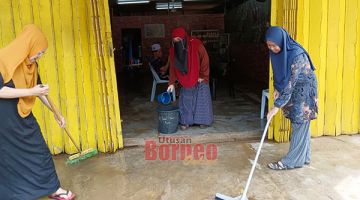 BANTU: Wanita Gagasan Rakyat turun padang membantu membersihkan premis yang dimasuki banjir.