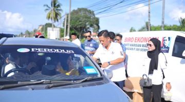 AGIH: Soh mengagihkan bubur kacang kepada pengguna jalan raya dalam program berkenaan.