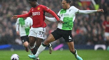 Pemain tengah Manchester United Kobbie Mainoo (kiri) bersaing mendapatkan bola dengan Van Dijk pada perlawanan Liga Perdana Inggeris di antara Manchester United dan Liverpool di Old Trafford di Manchester, kelmarin. — Gambar AFP