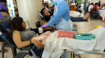 Seorang kakitangan HUS membantu penderma darah pada Program Derma Darah Yayasan Farley, hari ini.