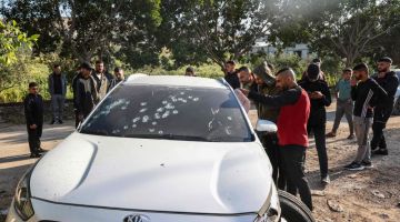 Sekumpulan lelaki Palestin memeriksa kereta yang dipenuhi lubang peluru selepas serbuan oleh tentera Israel di kem pelarian Al-Fara di wilayah Tebing Barat kelmarin. — Gambar AFP