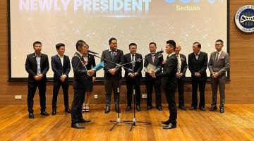 Wong (kanan) mengangkat sumpah sebagai presiden baharu JCI Seduan menggantikan Siow (kiri) sambil disaksikan Chieng (lima kiri, belakang) di Sibu hari ini.