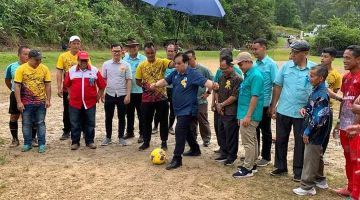 Dr Jerip (tengah) melakukan simbolik perasmian kejohanan dengan menyepak bola di Kampung Annah Sadir, semalam.