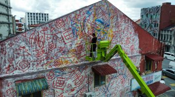 Siaw menggunakan teknik 'doodle grid' bagi lukisan mural terbaharunya di dinding sebuah banguan berdekatan pusat beli-belah Tun Jugah di Padungan. -Gambar Roystein Emmor