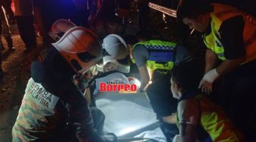 MAUT: Anggota polis dan bomba mengangkat mayat mangsa dalam kemalangan di Jalan Kampung Kelawat Kota Belud.