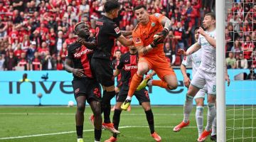 Pemain pertahanan Bayer Leverkusen Piero Hincapie (dua kiri) menanduk bola melepasi penjaga gol Bremen Michael Zetterer pada perlawanan Bundesliga Jerman di antara Bayer Leverkusen dan Werder Bremen di Leverkusen, kelmarin. — Gambar AFP