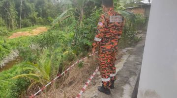 Anggota menjalankan pemeriksaan di bahagian belakang rumah yang terjejas. 