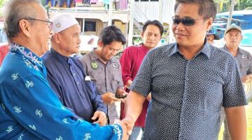 HADIR: Masiung (kanan) disambut orang ramai sebaik tiba merasmikan majlis berkenaan di Dewan Kuala Keramuak.