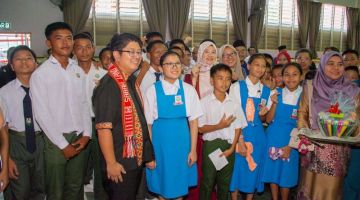 KENANGAN: Ewon dan Fadhlina merakamkan gambar kenangan bersama pelajar semasa lawatan terbabit.