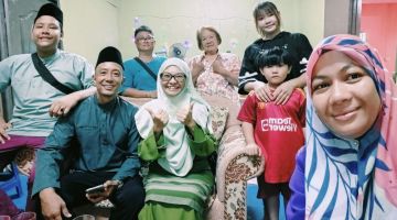 Abang Aien (duduk, dua kiri), anak dan isterinya, Zalina (duduk, tiga kiri) bersama rakan berbangsa Cina lain ketika mengunjungi kediaman wartawan Utusan Borneo (kanan) di Limbang.