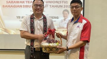 Yong (kanan) menyampaikan cenderamata kepada Chiew selepas merasmikan AGM STU di Sibu hari ini.