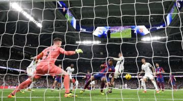 Bellingham (tiga kanan) merembat bola pada perlawanan La Liga Sepanyol di antara Real Madrid dan Barcelona di stadium Santiago Bernabeu di Madrid, kelmarin. — Gambar AFP