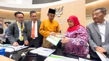 Abdul Karim bersama yang lain melihat pelan projek pembangunan pada sidang media semasa Majlis Ramah-Tamah Aidilfitri IRSDA hari ini. -Gambar Roystein Emmor