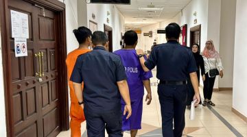 Polis mengiringi kedua-dua suspek kes ragut di Taman Desa Wira, Batu Kawa di Kompleks Mahkamah Kuching selepas permohonan reman tujuh hari ke atas mereka diluluskan hari ini. - Gambar Mohd Faisal Ahmad