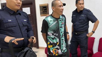 Polis mengiringi Madeng selepas prosiding di Mahkamah Sesyen, Kuching hari ini.