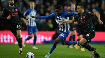 Pemain pertahanan Manchester City Nathan Ake (kanan) bersaing dengan pemain tengah Brighton Simon Adingra pada perlawanan Liga Perdana Inggeris di antara Brighton and Hove Albion dan Manchester City di Stadium Komuniti Khas Amerika di Brighton, England, kelmarin. — Gambar AFP