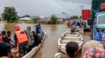 Penduduk dipindahkan dengan menaiki bot dari kawasan terjejas teruk akibat banjir selepas hujan lebat di kampung Mohoro, Daerah Rufiji baru-baru ini. — Gambar AFP