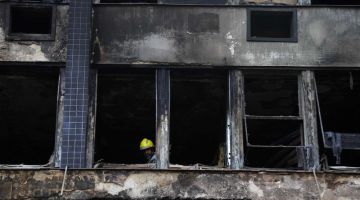 Anggota bomba berada di dalam bangunan yang separa musnah di Porto Alegre, Brazil untuk mengenal pasti punca kejadian. - Gambar AFP 