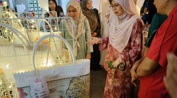 Fatimah (tengah) ditemani Dr Zufar (kanan) melihat beg straw yang unik rekaan Eureka by Azza salah satu vendor yang menyertai Seni Kita.