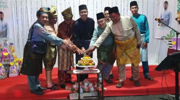 Azizul melakukan simbolik perasmian bersama tetamu lain pada Majlis Rumah Terbuka Aidilfitri Kampung Sileng Melayu Lundu, malam Sabtu lalu. 