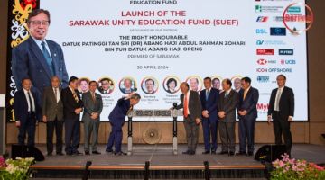 Dr Sim (lima kiri) mewakili Premier memukul gong sebagai simbolik pelancaran Dana Pendidikan Perpaduan Sarawak (SUEF) sambil disaksikan Richard (lima kanan) serta tetamu jemputan lain. - Gambar Roystein Emmor