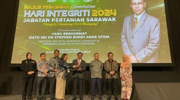 Dr Rundi (empat kanan) meletakkan tangan di atas skrin sebagai simbolik perasmian Hari Integriti Jabatan Pertanian Sarawak 2024 hari ini, sambil disaksikan Sirai (dua kiri), Martin (tiga kanan), Dr Abdul Rahman (tiga kiri) dan Dominic (dua kanan).