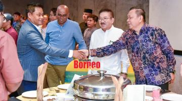 MESRA: Masiung (kiri) bersalaman dengan Ketua Pengarang Utusan Borneo Sabah Datuk Lichong Angkui (kanan) pada majlis itu. Turut kelihatan Presiden Persatuan Wartawan Sabah (SJA) Datuk Muguntan Vanar (dua kiri).