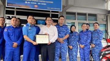 Chong menerima watikah pelantikan sebagai Penolong Pesuruhjaya Kehormat APM daripada Zakwan (dua kiri) sambil disaksikan Pegawai Unit Bencana Operasi dan Latihan APM Leftenan (PA) Mohd Zaidi Mohd Ali (empat kiri) serta anggota APM lain.