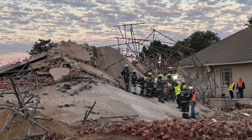 Pekerja penyelamat dilihat di tapak sebuah bangunan lima tingkat yang runtuh ketika sedang dalam pembinaan di bandar George kelmarin. — Gambar AFP