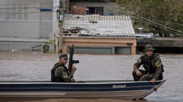 Anggota tentera kelmarin meronda menggunakan bot di kawasan kejiranan Humaita di Porto Alegre, Rio Grande do Sul yang dilanda banjir. — Gambar AFP