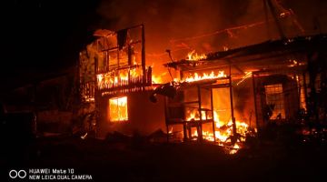RENTUNG: Api marak memusnahkan rumah dua tingkat di Kampung Lasing, di sini.