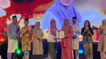 Fatimah menyempurnakan penyerahan penghargaan kepada Bibi Razali, pegawai KWPK yang bakal bersara pada Majlis Makan Malam Apresiasi DUN Mei 2024, sambutan Hari Raya dan Pra-Gawai 2024 di sebuah hotel di Kuching, malam Selasa.