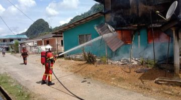 Anggota bomba berusaha memadam kebakaran rumah yang turut memusnahkan sebuah kereta dan tiga motosikal di Kampung Bantang, Serian hari ini.