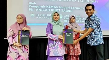 Anisah (tengah) menyampaikan sijil tamat kursus kepada salah seorang peserta bengkel tersebut.