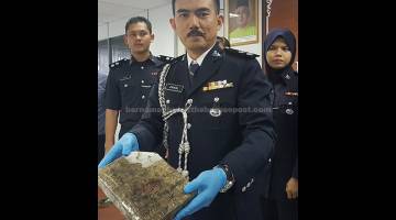 SIDANG MEDIA: Mohamad Zainal menunjukkan dadah ganja mampat bernilai RM10,000 yang dirampas polis selepas menahan sepasang kekasih termasuk seorang penjawat awam dipercayai pengedar di Tanjung Belanja dekat Seri Iskandar, semalam. — Gambar Bernama