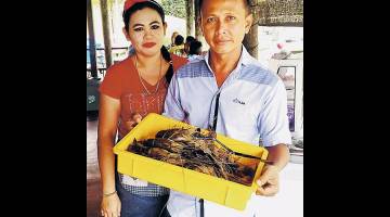 SEDAP: Azizi dan Noridah menunjukkan udang galah yang menjadi menu utama di kedai makan mereka di pasar lama Balingian.