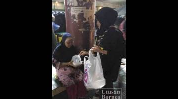SEORANG ahli pengakap menyampaikan bantuan makanan kepada salah seorang wanita yang tiada tempat tinggal.