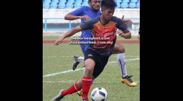 HALANG: Penyerang SSN Sarawak, Mohd Faris cuba dihalang pemain UiTM Sarawak FC, Muhammad Adib (jersi biru) pada aksi K-League 2018 di Stadium Sarawak, Petra Jaya semalam.